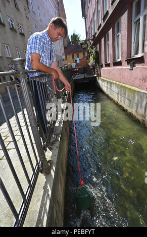 Augsburg, Allemagne. 19 juillet, 2018. Klaus Wengenmayr tire son eau du Lech Canal devant son restaurant. Le papier de l'artiste et propriétaire de pub papier artisanal produit à partir de l'eau qu'il vend dans le monde entier (pour dpa séries estivales : 'Menschen am Fluss' et le 'Lechwasser Elefantenkot KORR, Schafwolle ergibt exklusives und papier' à partir de 15.08.2018). Credit : Karl-Josef Opim/dpa/Alamy Live News Banque D'Images