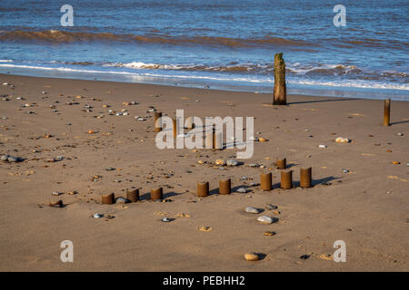 Côte de la mer du Nord à Caister-on-Sea, Norfolk, England, UK - avec les restes d'un disjoncteur sur la plage vagues Banque D'Images