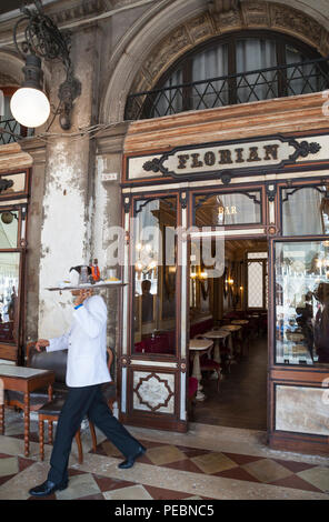 Serveur avec plateau sortant de Caffe Florian, Piazza San Marco, San Marco, Venise, Vénétie, Italie. Motion blur, ouvert en 1720, c'est le plus ancien café d'Italie Banque D'Images