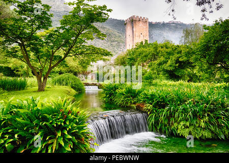 Ruisseau en cascade dans un jardin doté d'une tour médiévale, Latina Italie Banque D'Images