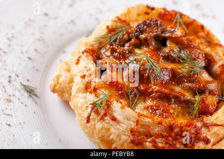 Tarte de viande juteuse, ragoût de boeuf tarte avec la pâte feuilletée. Des produits fraîchement sortis du pays, style rustique. Pot Pie avec du fromage on white plate Banque D'Images