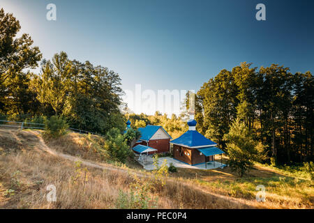 Chernoye, région de Gomel (Bélarus). La chapelle en bois orthodoxe de la Sainte Sainte Matrona de Moscou en journée ensoleillée. Près de chapelle il y a un printemps saint ou W Banque D'Images