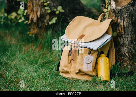 Vue rapprochée de sac à dos avec boussole et carte on Green grass Banque D'Images