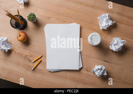 Vue du dessus de la pile de documents vierges sur table en bois avec des papiers froissés Banque D'Images