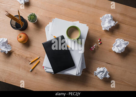 Vue du dessus de la pile de documents vierges avec tasse de café et des portables sur le dessus de table en bois Banque D'Images