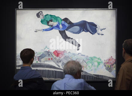 Visiteurs en face de la peinture 'sur la ville' par peintre moderniste russe Marc Chagall (1914-1918) présentés à l'exposition au Centre Pompidou à Paris, France. L'exposition consacrée à l'avant-garde russe dans la région de Vitebsk (1918-1922) s'étend jusqu'au 16 juillet 2018. Banque D'Images