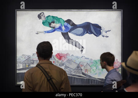 Visiteurs en face de la peinture 'sur la ville' par peintre moderniste russe Marc Chagall (1914-1918) présentés à l'exposition au Centre Pompidou à Paris, France. L'exposition consacrée à l'avant-garde russe dans la région de Vitebsk (1918-1922) s'étend jusqu'au 16 juillet 2018. Banque D'Images