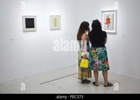 Visiteurs en face de la peinture d'avant-garde Russe Nikolai Suetin peintre intitulé 'Composition' (1920) présentés à l'exposition au Centre Pompidou à Paris, France. Peintures de Nikolai Suetin depuis le début des années 1920 "Composition avec une bande jaune" au centre et 'Carré noir' à la gauche, qui est une copie d'après le célèbre tableau du peintre d'avant-garde russe Kazimir Malevich, sont vus dans l'image. L'exposition consacrée à l'avant-garde russe dans la région de Vitebsk (1918-1922) s'étend jusqu'au 16 juillet 2018. Banque D'Images