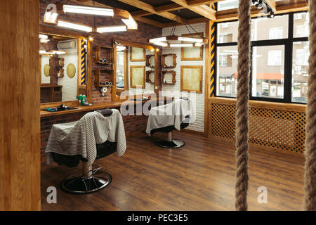 Des chaises vides et des miroirs à l'intérieur salon de coiffure moderne Banque D'Images