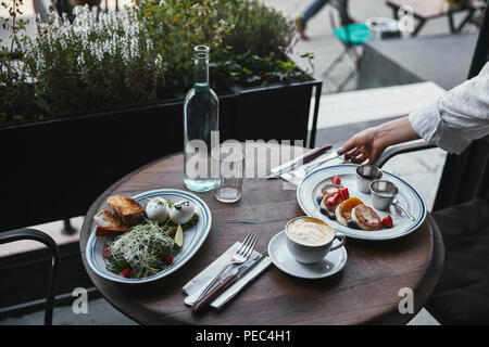 Cropped shot of woman création table avec des plats délicieux au restaurant Banque D'Images