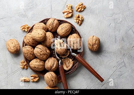 Noix et cerneaux entiers sur fond gris et Casse-Noisette. Banque D'Images