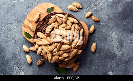 Amandes non décortiquées sur fond de béton gris avec copie espace. Vue d'en haut. Banque D'Images