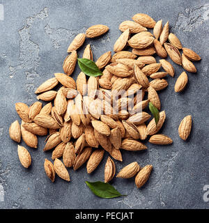 Amandes non décortiquées sur fond de béton gris. Vue d'en haut. Banque D'Images