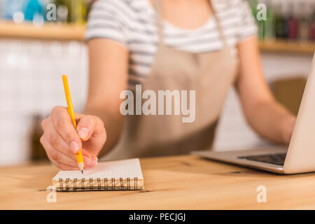 Pour les notes. Focus sélectif d'un portable étant en cours d'utilisation par une belle femme agréable intelligente tout en travaillant dans le café Banque D'Images