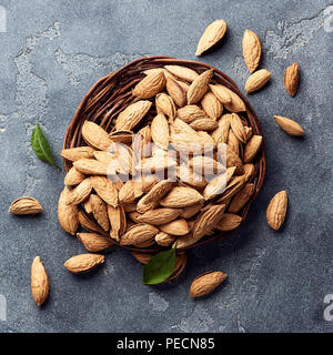 Amandes non décortiquées sur fond de béton gris. Vue d'en haut. Banque D'Images