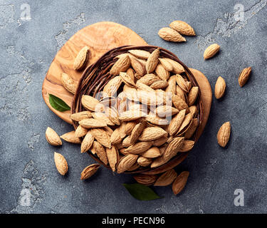 Amandes non décortiquées sur fond de béton gris. Vue d'en haut. Banque D'Images