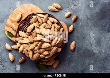 Amandes non décortiquées sur fond de béton gris. Vue d'en haut. Banque D'Images