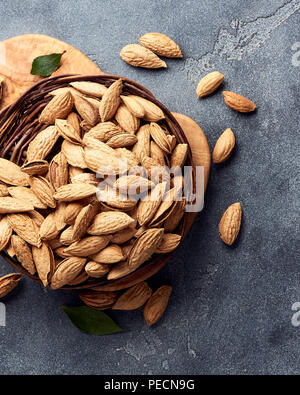 Amandes non décortiquées sur fond de béton gris. Vue d'en haut. Banque D'Images