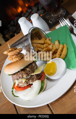 Double hamburger fait maison et fromage avec un seau ou seau de croustilles de pommes de terre/frites et moutarde anglaise Banque D'Images