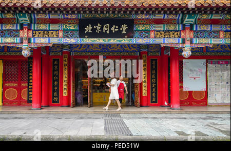 Les gens qui marchent par Beijing Tong Ren Tang, une boutique de la médecine traditionnelle chinoise à Chengdu, Sichuan, Chine Banque D'Images