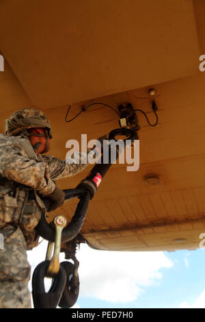 Un parachutiste de la 3e Brigade Combat Team, 82e Division aéroportée, crochets d'un pendentif, atteindre à un CH-47 Chinook affecté à la 82e, 82e Brigade d'aviation de combat Abn. Div. lors d'une mission d'assaut aérien combiné, Fort Bragg, Caroline du Nord, le 4 août. Le parachutiste du 1er Bataillon du 508th Parachute Infantry Regiment, 3BCT, élinguer une charge M1151 Humvee pour le transport vers un objectif ainsi que du bataillon de parachutistes. (U.S. Photo de l'armée par le sergent. Christopher Freeman/ 82e CAB PAO) Banque D'Images