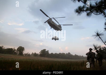 Des parachutistes du 1er bataillon du 508e régiment d'infanterie parachutiste observent un hélicoptère Boeing CH‑47 Chinook de la 82e brigade d'aviation de combat qui effectue un levage de charge à élingue d'un Humvee lors d'un entraînement d'assaut aérien conjoint à Fort Bragg, en Caroline du Nord. Les turboréacteurs jumelés Honeywell T55 et la conception du rotor tandem du CH‑47 offrent une capacité de levage lourd pour le transport d’équipement et de troupes dans les opérations d’assaut aérien et de charge tactique soutenant les unités aéroportées.  :ContentReference[oaicite :1]{index=1} Banque D'Images
