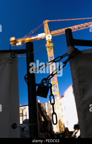 La Lettonie, Riga. Serrure et la chaîne sur la porte en s'appuyant sur un fond de la grue jaune et un ciel bleu Banque D'Images