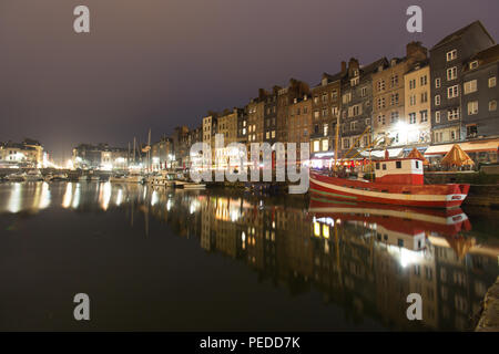 Ville de Honfleur, France. Vue nocturne pittoresque du Vieux bassin de Honfleur avec le Quai Sainte-Catherine en arrière-plan. Banque D'Images