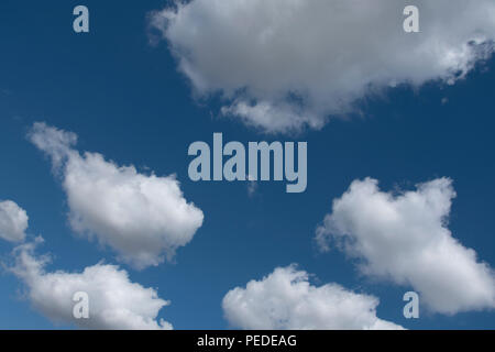 Les formations de nuages duveteux contre un ciel bleu profond. Banque D'Images