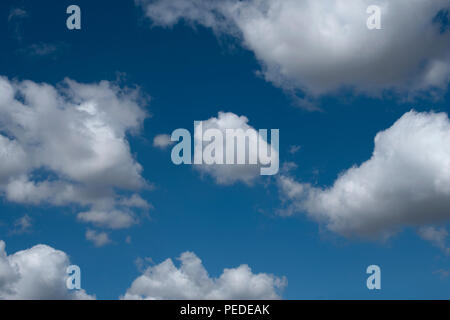 Les formations de nuages duveteux contre un ciel bleu profond. Banque D'Images