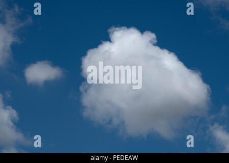 Les formations de nuages duveteux contre un ciel bleu profond. Banque D'Images