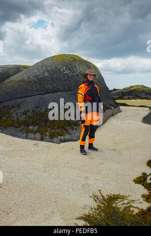 Jeune femme portant un kayakiste de mer jaune combinaison étanche. Banque D'Images