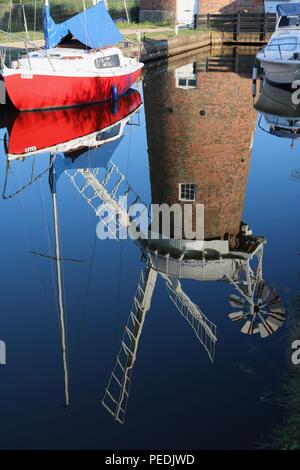 Reflet de la pompe et un vent Horsey yacht rouge dans l'eau de la Norfolk Broads en plein soleil Banque D'Images