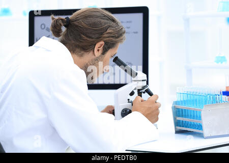 Technicien en laboratoire principal à l'aide de microscope in laboratory Banque D'Images