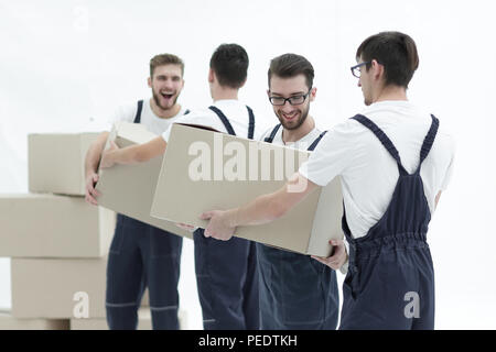 Les travailleurs passent chaque photo autres cases lors du déplacement d'appartements. Banque D'Images