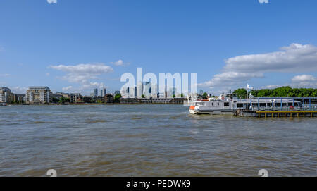 Greenwich, London, UK - 10 août, 2018, Greenwich Pier avec rivière cruiser amarré et vue sur Canary Wharf en arrière-plan. Banque D'Images