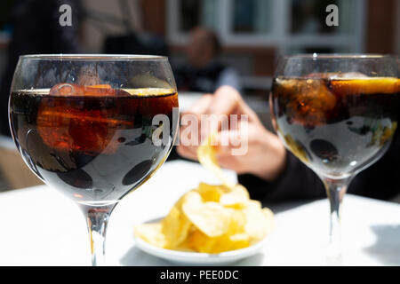 Libre de deux verres avec vermouth, un vin servi sur les rochers avec une tranche d'orange, et un bol de croustilles, mangé traditionnellement un Banque D'Images