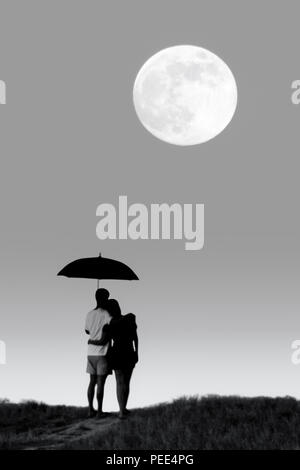 Couple Silhouette debout sur la colline regardant fullmoon et holding umbrella en noir et blanc Banque D'Images