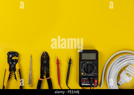 Outils d'installation électrique sur fond jaune avec copie espace Banque D'Images