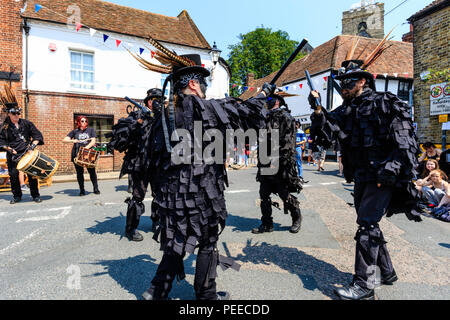 Danse folklorique traditionnel anglais, Wolfs chef Morris dance, côté en noir vestes tatter, danser dans la rue à la Folk Festival Ale et Sandwich. Banque D'Images