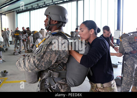 Un soldat américain affecté à l'United States Special Operations Command attend patiemment que son maître n'Jump un contrôle final sur son équipement pendant un cours de qualification de saut s'est tenue à Stuttgart Army Airfield à Stuttgart, Allemagne, le 5 août, 2015. (U.S. Photo de l'armée par Visual Spécialiste de l'information, Adam Sanders/libérés) Banque D'Images