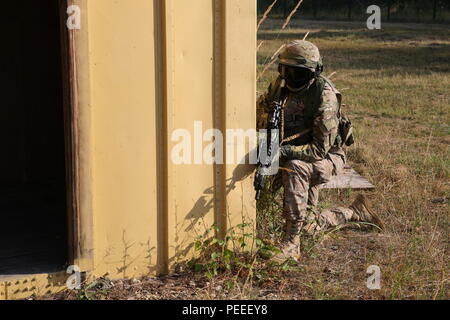 Un soldat géorgien affecté à la Compagnie Bravo du 22e Bataillon d'infanterie légère, 2e Brigade d'infanterie fournit la sécurité de derrière un bâtiment tout en effectuant une patrouille urbaine voie de formation au cours d'un exercice de répétition de mission (MRE) au Centre de préparation interarmées multinationale à Hohenfels, Allemagne, July 9, 2015. La conduite des soldats géorgiens aux côtés de MRE mentors U.S. Marine Corps avant de déployer en Afghanistan afin d'aiguiser les compétences nécessaires à l'exploitation de la Force internationale d'assistance aux côtés de forces des partenaires dans un environnement de contre-insurrection. (U.S. Photo de l'armée par la CPS. Brian Chaney/ Banque D'Images