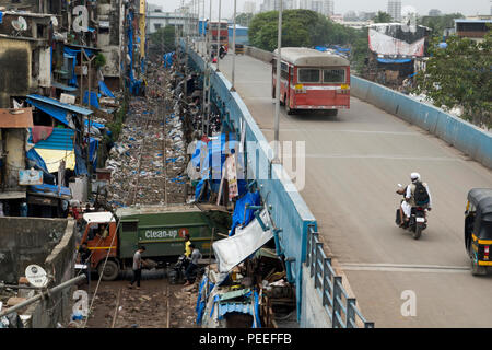 Camion Poubelle passe sous station Road Station road et sur les voies couvertes de déchets en plastique à Bandra, Mumbai, Inde Banque D'Images