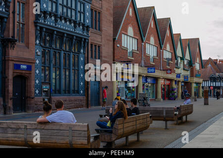 Chester, Royaume-Uni : Aug 6, 2018 : Les gens prennent une pause et s'asseoir sur des bancs dans la zone commerçante de Chester. Banque D'Images