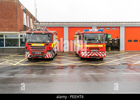 Camions de lutte contre l'incendie de la caserne de pompiers stationné à l'extérieur sous la pluie Banque D'Images