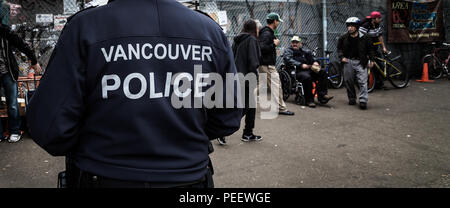 VANCOUVER, BC, CANADA - 11 MAI 2016 : agent de police de Vancouver en patrouille dans une zone de forte consommation de drogue et de la pauvreté qui est le Downtown Eastside de Vancouver. Banque D'Images