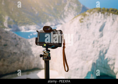 L'appareil photo numérique sur trépied contre d'énormes rochers falaise de la plage de Navagio matin dans la lumière du soleil. Visite de monument célèbre emplacement sur l'île de Zakynthos, Grèce Banque D'Images