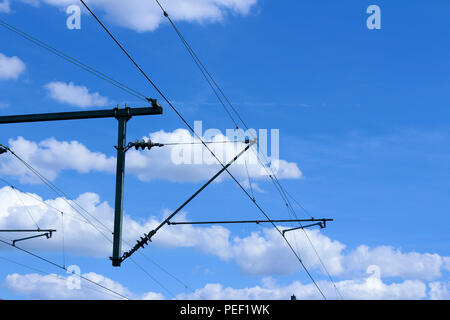 Les lignes de trains électriques électrification ferroviaire système aérien avec des câbles et ciel bleu au-dessus Banque D'Images
