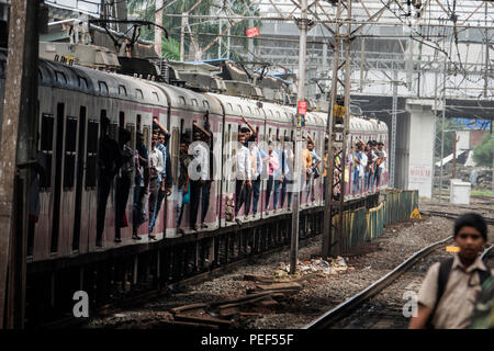 Les passagers des trains de banlieue de Mumbai porte sur un train de chemin de fer à la gare de Bandra à Mumbai, Inde Banque D'Images