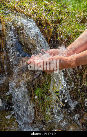 L'eau de source coule sur les mains, le Parc National du Hohe Tauern, le Tyrol, Autriche Banque D'Images